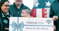An image of a group of people holding a check being presented to Beds for the brave